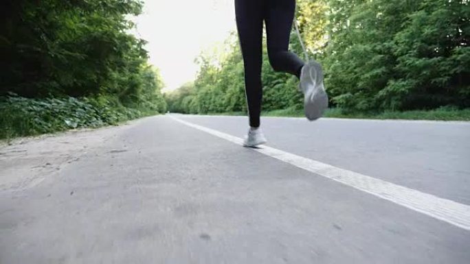 在乡村开阔的道路上奔跑的女跑步者