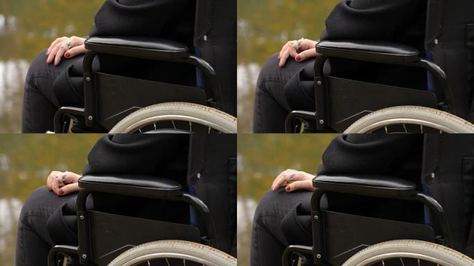 残疾，悲伤，孤独-坐轮椅的女人的手在湖上