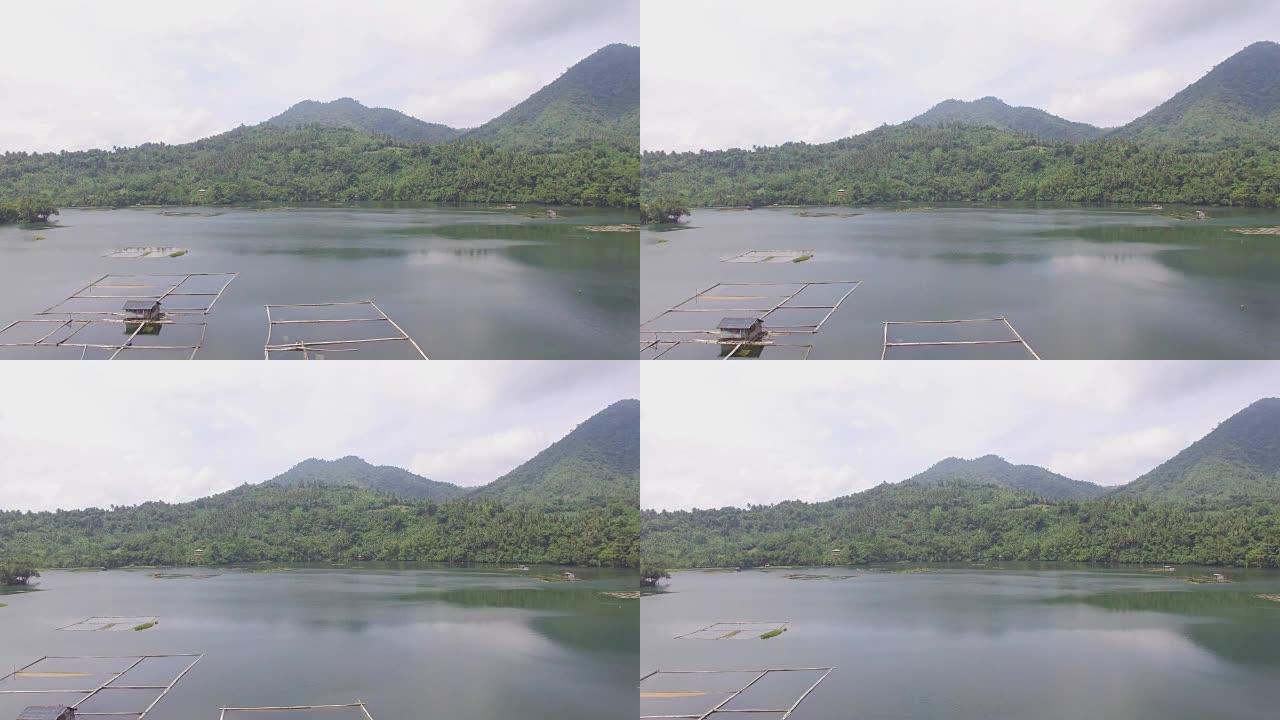 水产养殖利用Mojicap湖的潜力来维持湖泊居民的生计。建在湖中的棚户区和竹子结构。无人机航拍