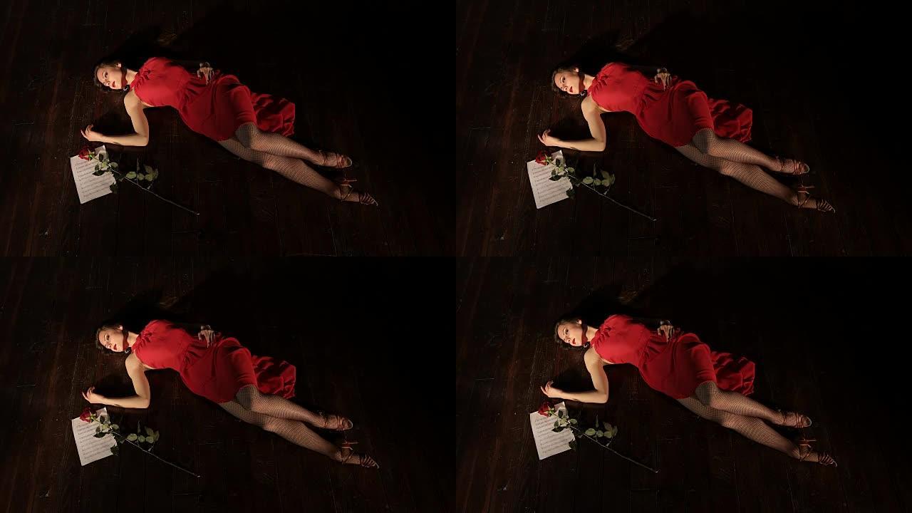 一个穿着红色连衣裙的年轻时尚女孩死于躺在地板上的不快乐的爱情。