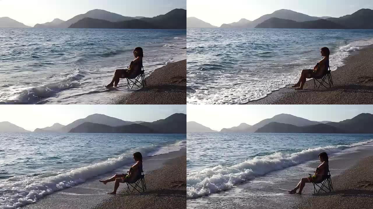 女人坐在沙滩上的沙滩上。