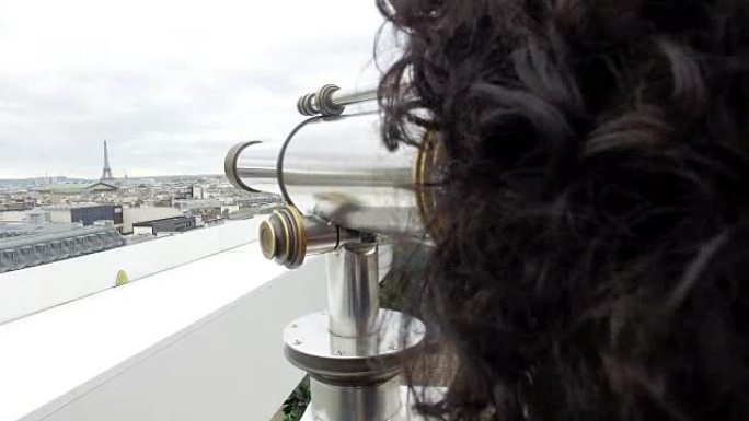 用投币式双目望远镜在拉斐特画廊露台上的埃菲尔铁塔俯瞰巴黎景观的游客