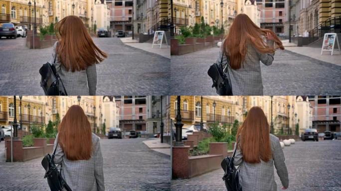 长着姜黄色长发的年轻女子在城市中行走并向后看，背着背包，城市街道背景，后视图