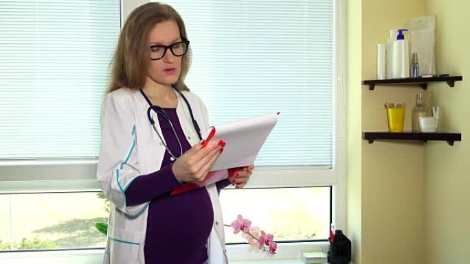怀孕的女医生在工作中看着剪贴板文件夹。静态的照片