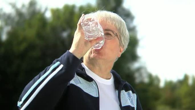 老年妇女在户外喝水