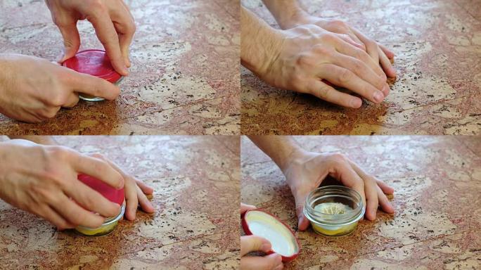 男人的手的特写镜头用盖有霉菌的柠檬罐拧开盖子。