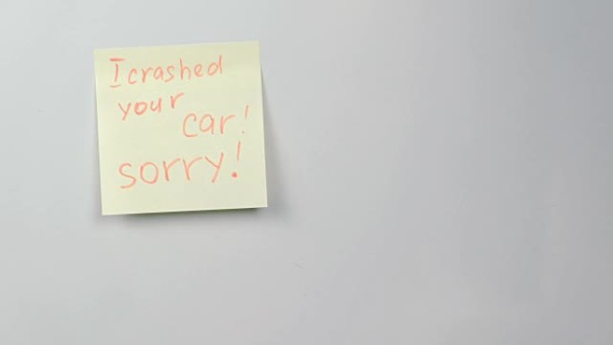 特写黄色贴纸纸，上面写着我撞坏了你的车，对不起冰箱。