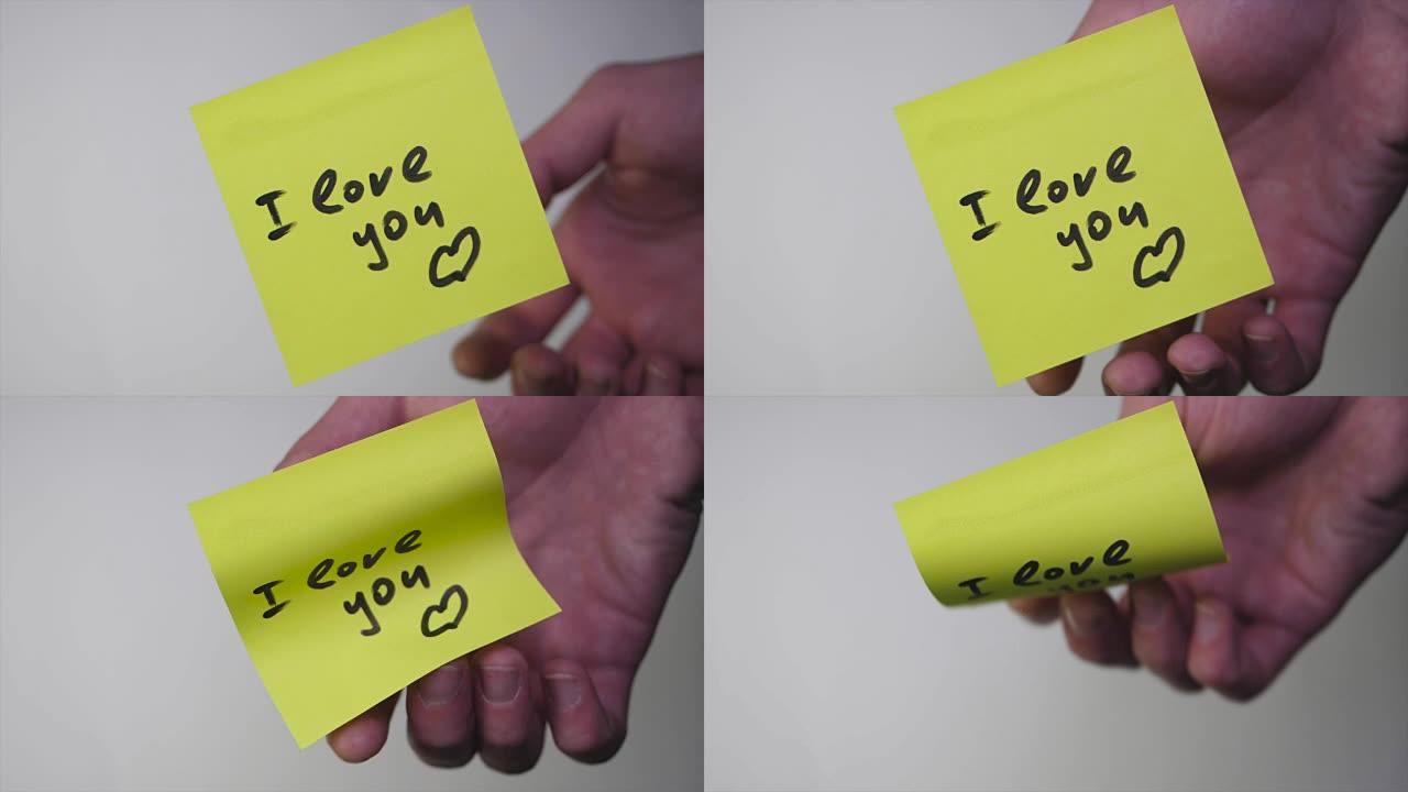 在黄纸上画 “我爱你”。白底贴纸上的题字我爱你