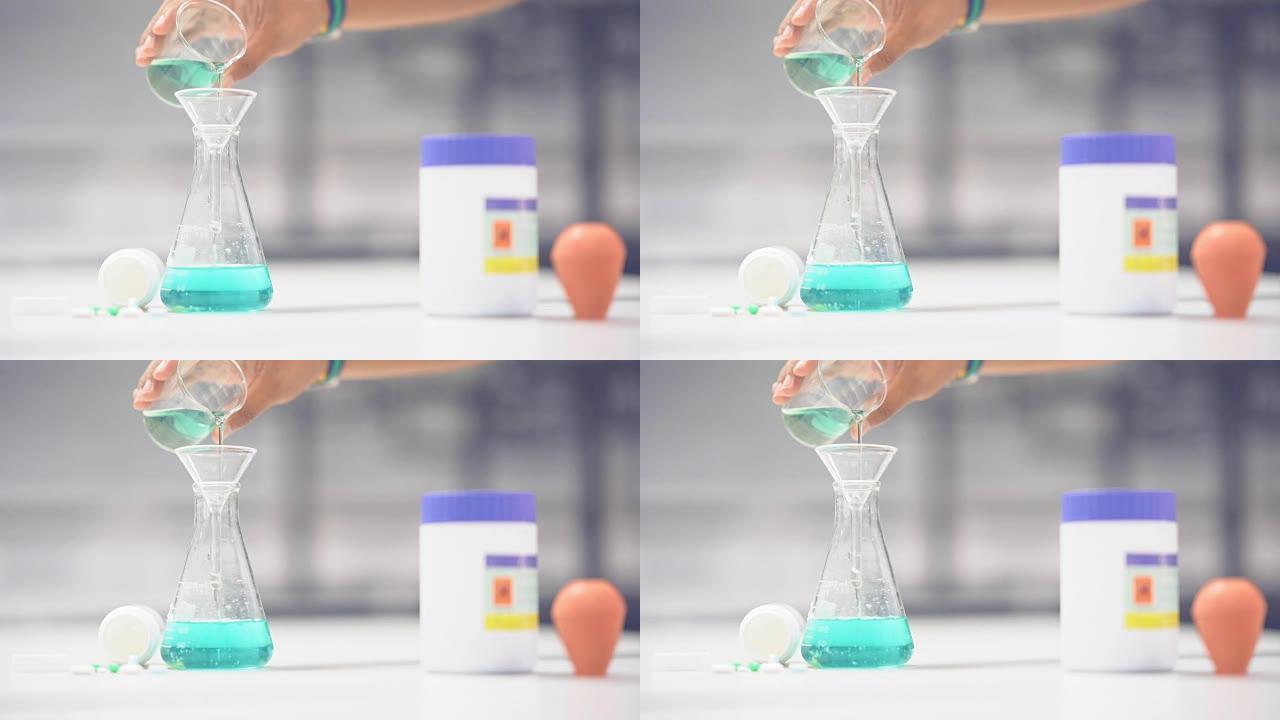 亮慢动作化学溶液倒在烧瓶上，用于测试药物在桌子上的化学反应