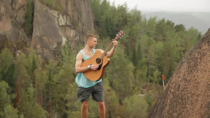 一个站在山顶上弹吉他的人。
