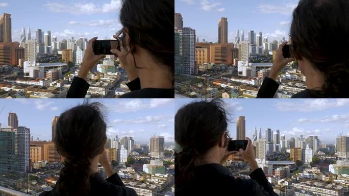 旅游男子用手机拍摄大城市景观