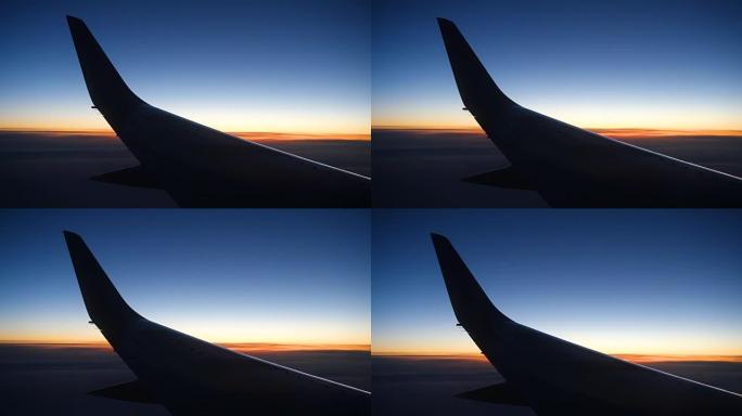 飞机机翼在日落时，云层在上面