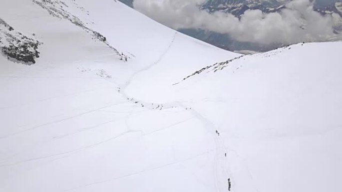 旅游团在冬季旅行中攀登雪山高峰