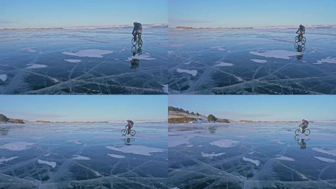 人在冰上骑自行车。骑自行车的人穿着灰色羽绒服，背包和头盔。冰冻的贝加尔湖的冰。自行车上的轮胎上覆盖着