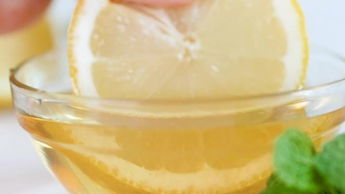 用蜂蜜将柠檬片浸入玻璃罐中的特写慢动作镜头