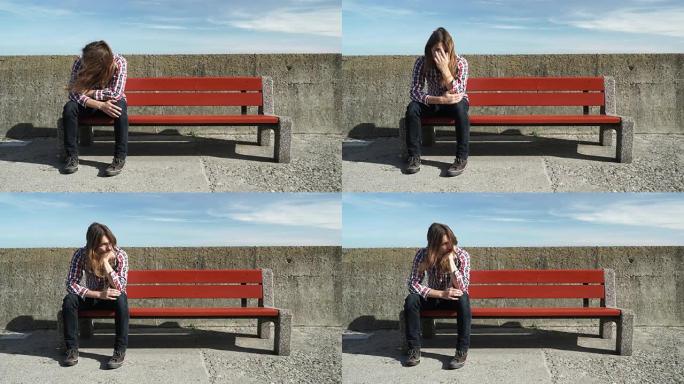 一个人独自坐在长凳上，忧心忡忡，情绪低落4K