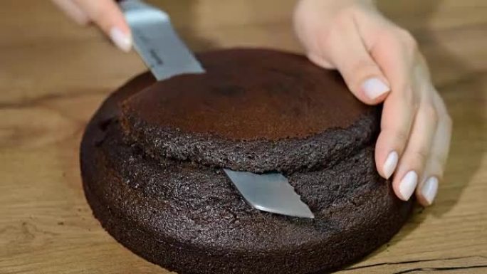 女人切掉巧克力蛋糕的顶部