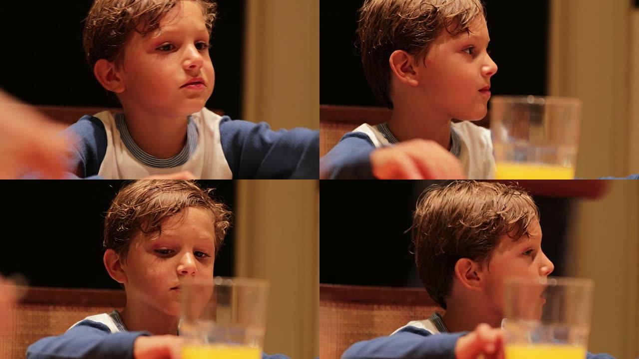 坦率的现实生活中，孩子在餐桌上的瞬间将橙汁杯放在他旁边，并注意周围发生的社会动态