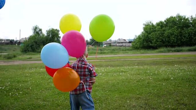 快乐男孩在公园玩气球。散步和户外活动