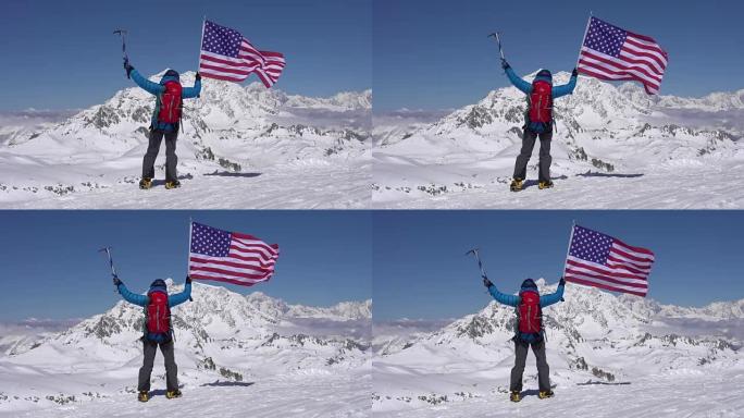 站在白雪皑皑的山顶上的登山者放弃了美利坚合众国的国旗。