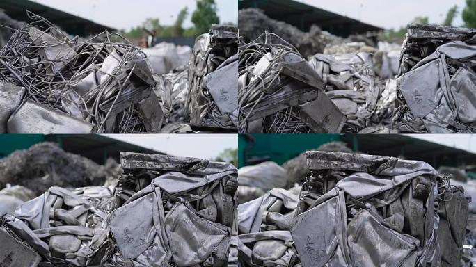 在阴天的夏日，大型压制煤球和金属废料躺在垃圾场的室外