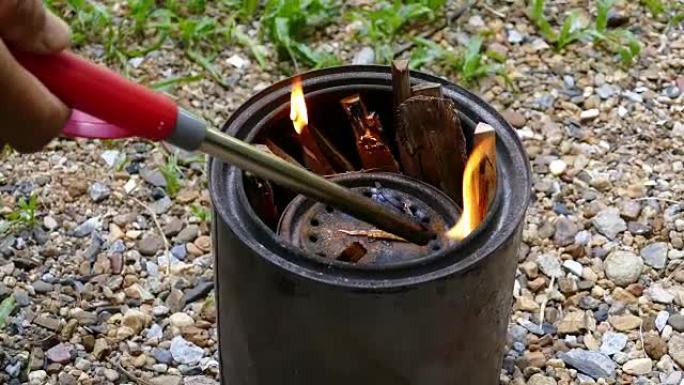 用手烧制炉子中的木材起动器将原木燃烧成木炭