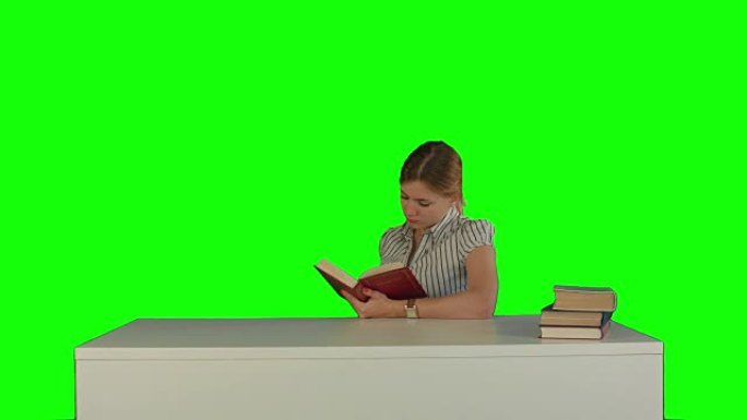 女学生在绿屏上看书查找信息