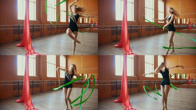 体操-年轻女子用绿丝带慢动作训练体操