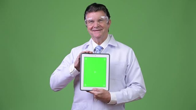 高级帅哥医生戴防护眼镜展示数码平板