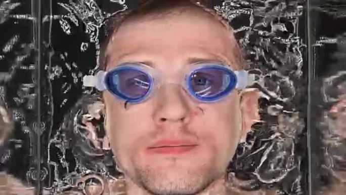 戴眼镜的人低下头进入水中，屏住呼吸，用空气吹泡泡