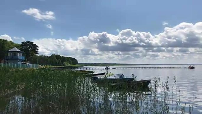 淡水湖上晴朗的天气。在海浪上岩石船和游艇。在蓝天上郁郁葱葱的云朵。
