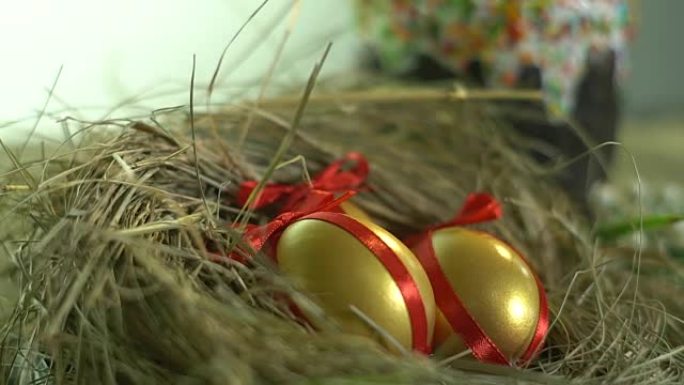 鸟巢里有丝带的金蛋和复活节蛋糕，春假