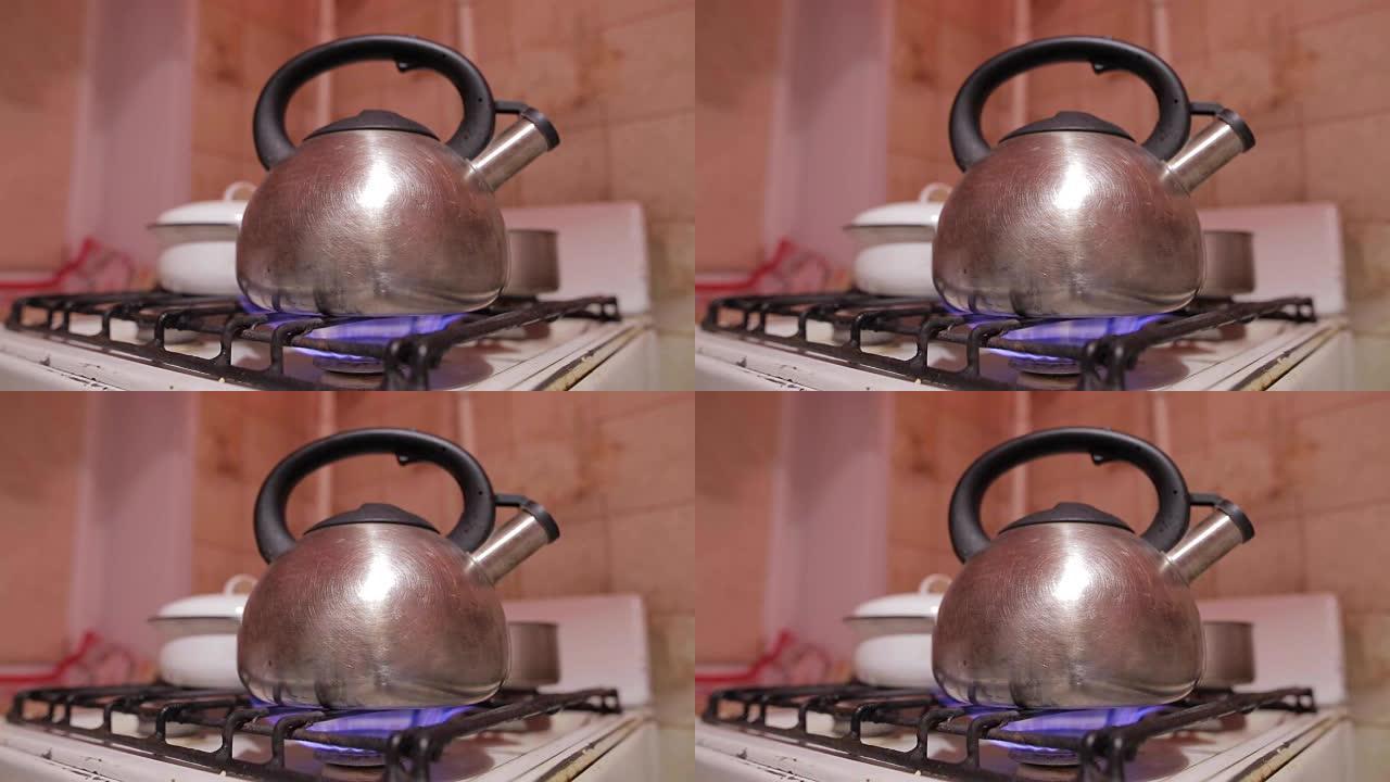 在开始蒸汽时，用金属茶壶加热旧煤气炉上的水的特写镜头