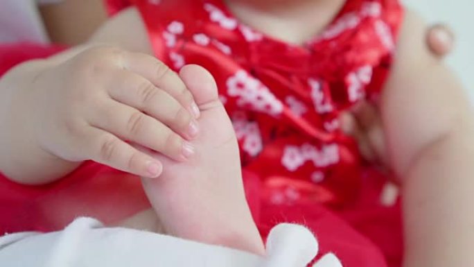 在小女婴试图用自己的脚在慢动作镜头中触摸和玩耍时，在婴儿脚上特写