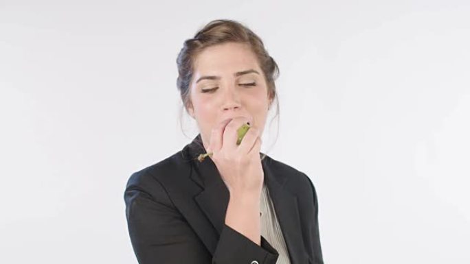 女人在白色工作室背景上吃梨