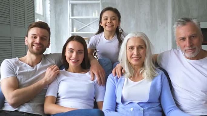 坐在沙发上的幸福家庭。慢动作