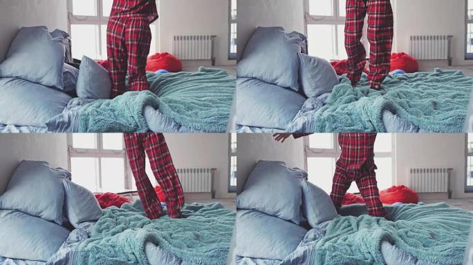 一个穿着睡衣的年轻女子的腿特写，她正跳到家里的特大号床上。慢动作。3840x2160