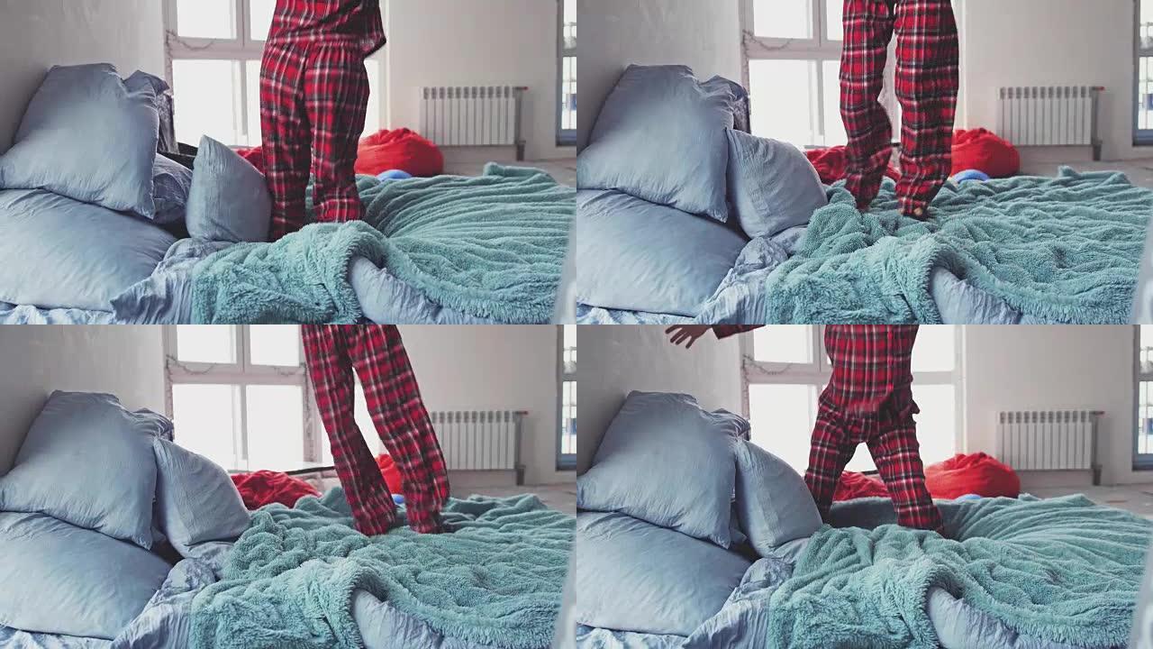 一个穿着睡衣的年轻女子的腿特写，她正跳到家里的特大号床上。慢动作。3840x2160