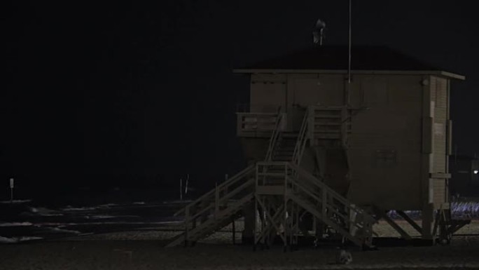 夜间海滩上闪烁的救生员塔