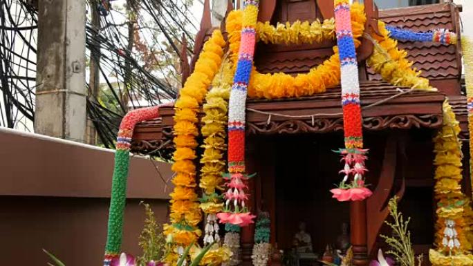 泰国花园中装饰精美的传统佛教祭坛，鲜花和各种象征性人物