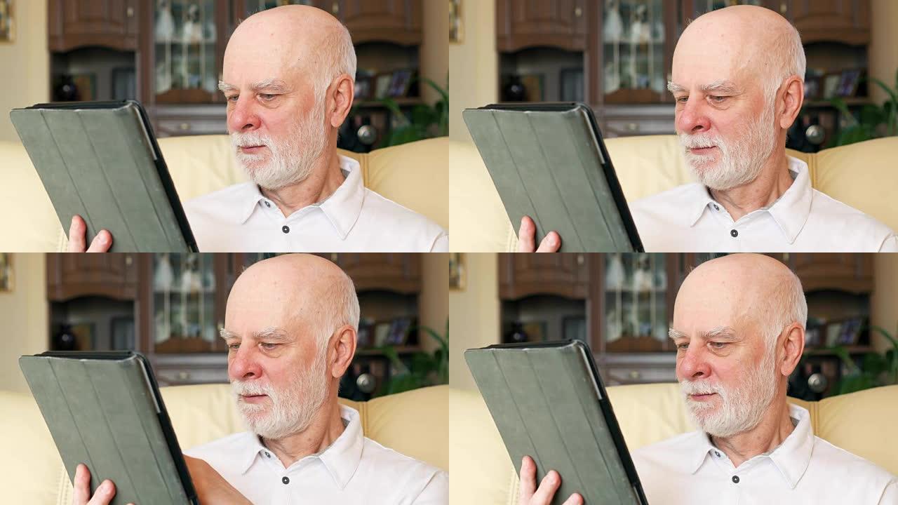 现代高级男人在家使用平板电脑，浏览，阅读新闻。退休后积极的现代生活