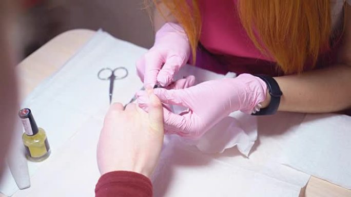 修指甲。修指甲的主人在剪刀的帮助下从指甲上去除角质层。美容院的专业修指甲。全高清