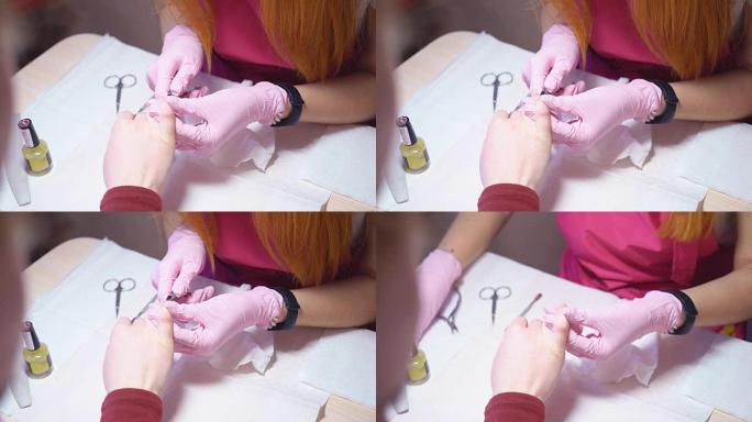 修指甲。修指甲的主人在剪刀的帮助下从指甲上去除角质层。美容院的专业修指甲。全高清