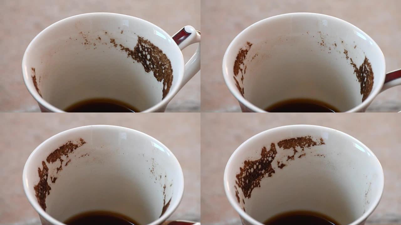 在咖啡渣上猜测。带咖啡渣的咖啡杯旋转。特写