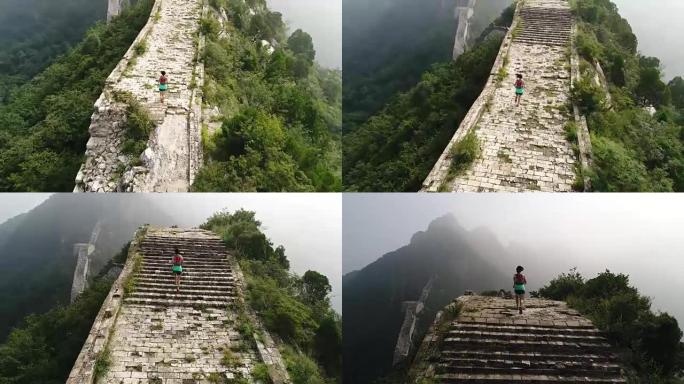 在长城顶上奔跑的年轻健身女子越野跑运动员的鸟瞰图