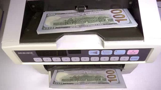 电子点钞机正在计数美国百元美元纸币
