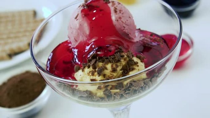 五颜六色的冰淇淋球倒入红色果酱。