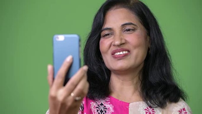 成熟快乐美丽的印度女人用电话视频通话