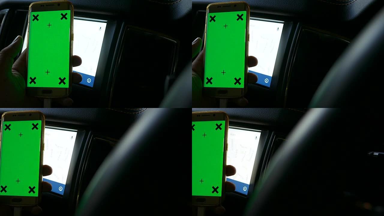 驾驶员在汽车中使用带有绿屏的智能手机，色键，多莉射击