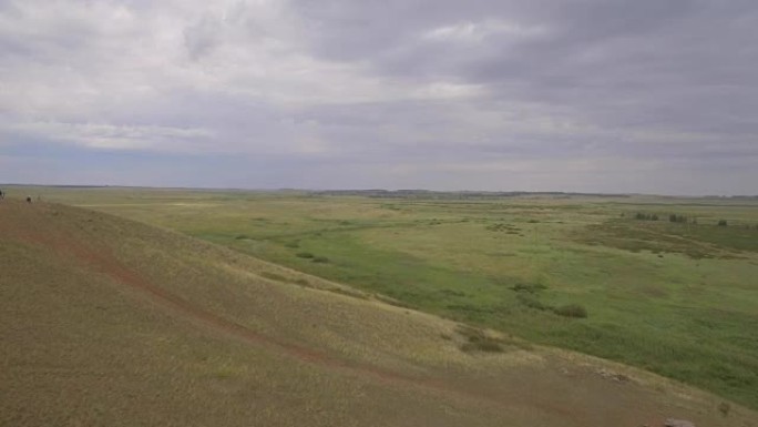 青山带人，夏天，鸟瞰图。草山和土路顶视图。美丽的夏日风景